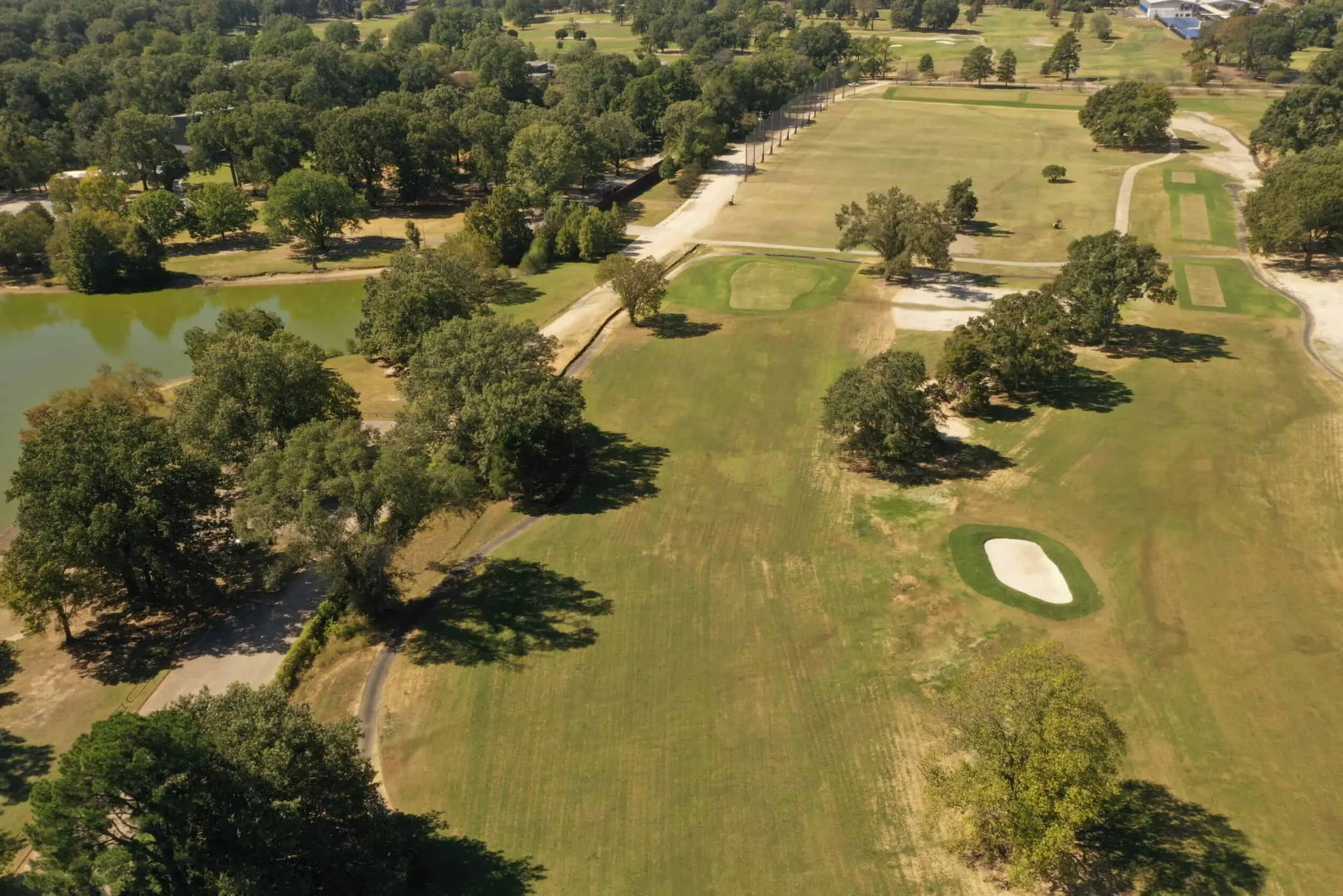 Aerial view of fairways and greens among mature trees
