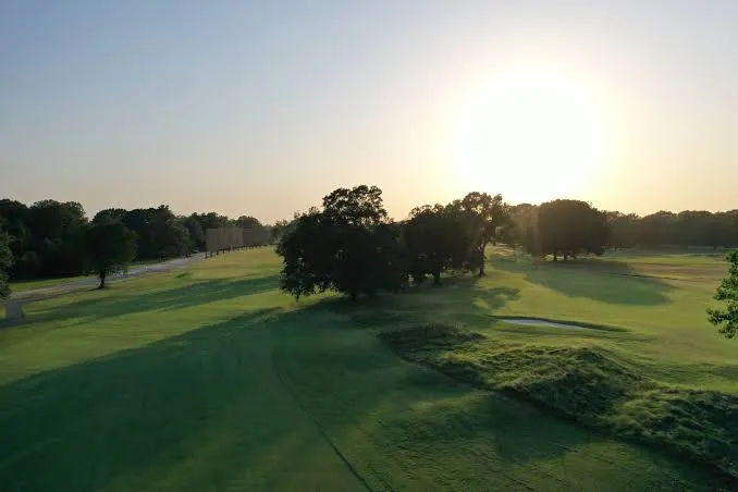 Morning sun over a fairway and bunkers