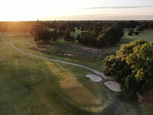 A cart path winding through the course at sunset