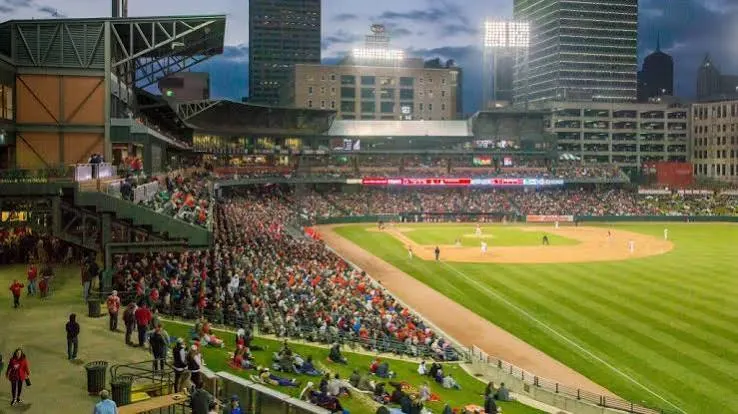 Fans on the outfield lawn, the skyline behind