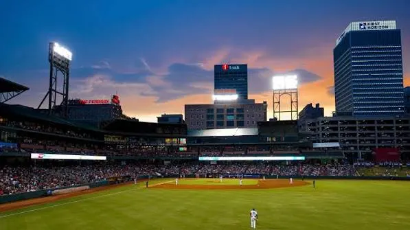 The ballpark lit at dusk, the skyline beyond the outfield