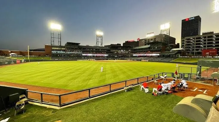 The outfield at dusk under the stadium lights