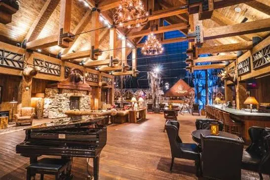 The lobby's grand piano and leather chairs under antler chandeliers