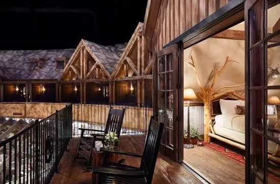 A guest room balcony with rocking chairs among the cabin rooflines