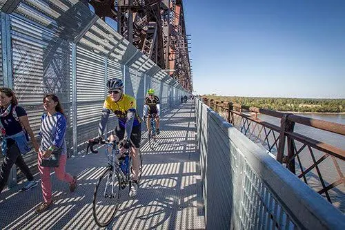 Walkers and cyclists on the boardwalk beside the truss