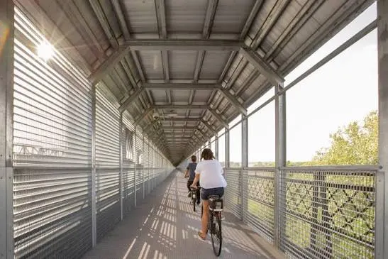 A cyclist in the screened section of the walkway