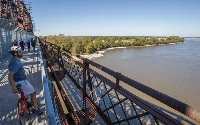 A cyclist on the boardwalk high above the river