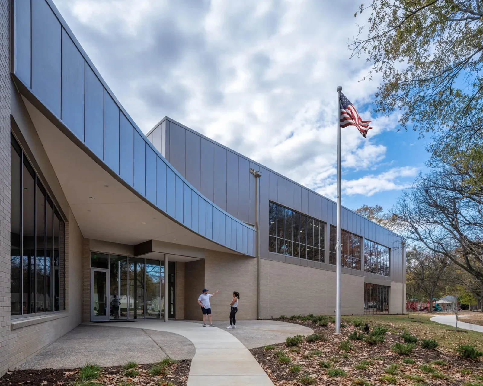 The curved entrance canopy and flagpole on a bright afternoon