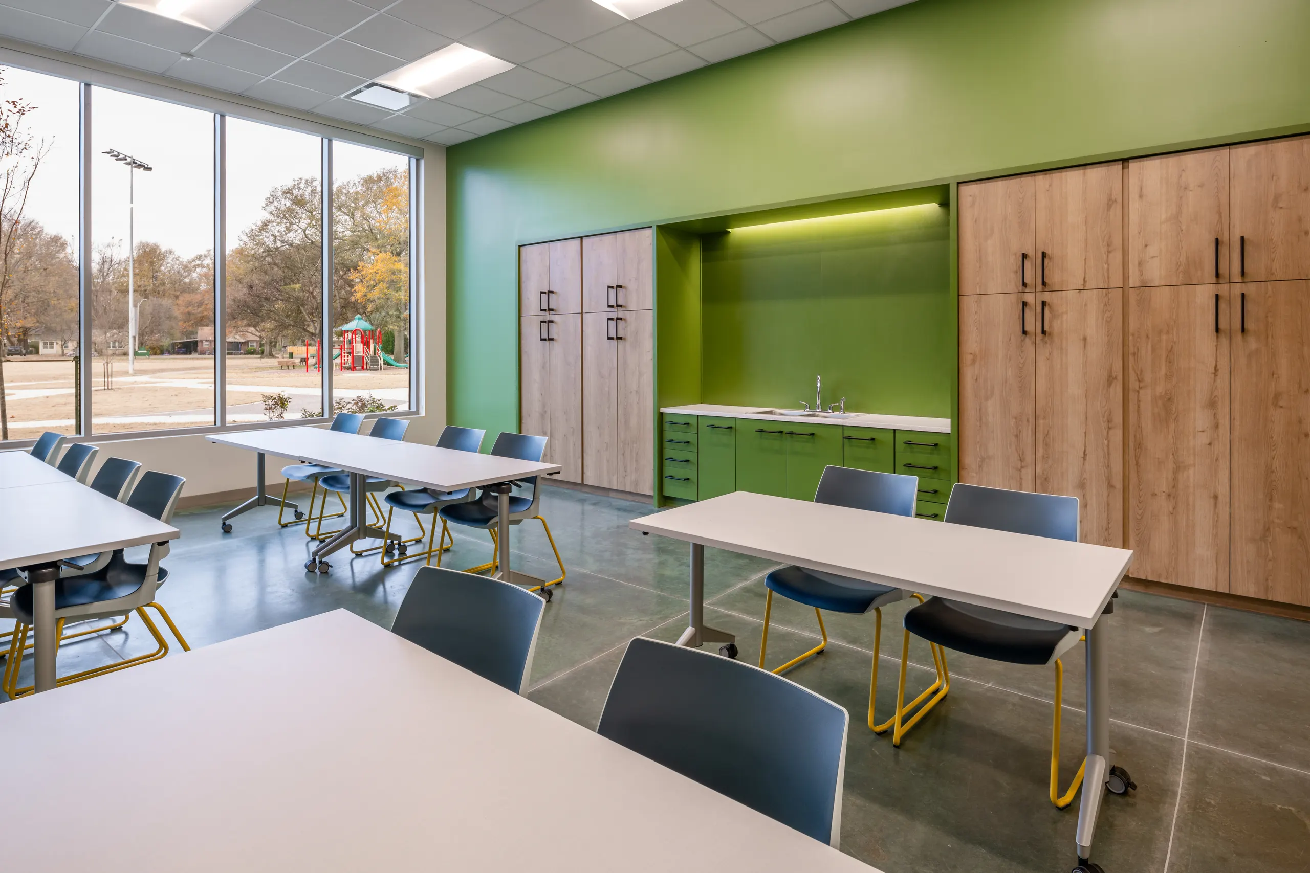 A classroom with green cabinetry and daylight