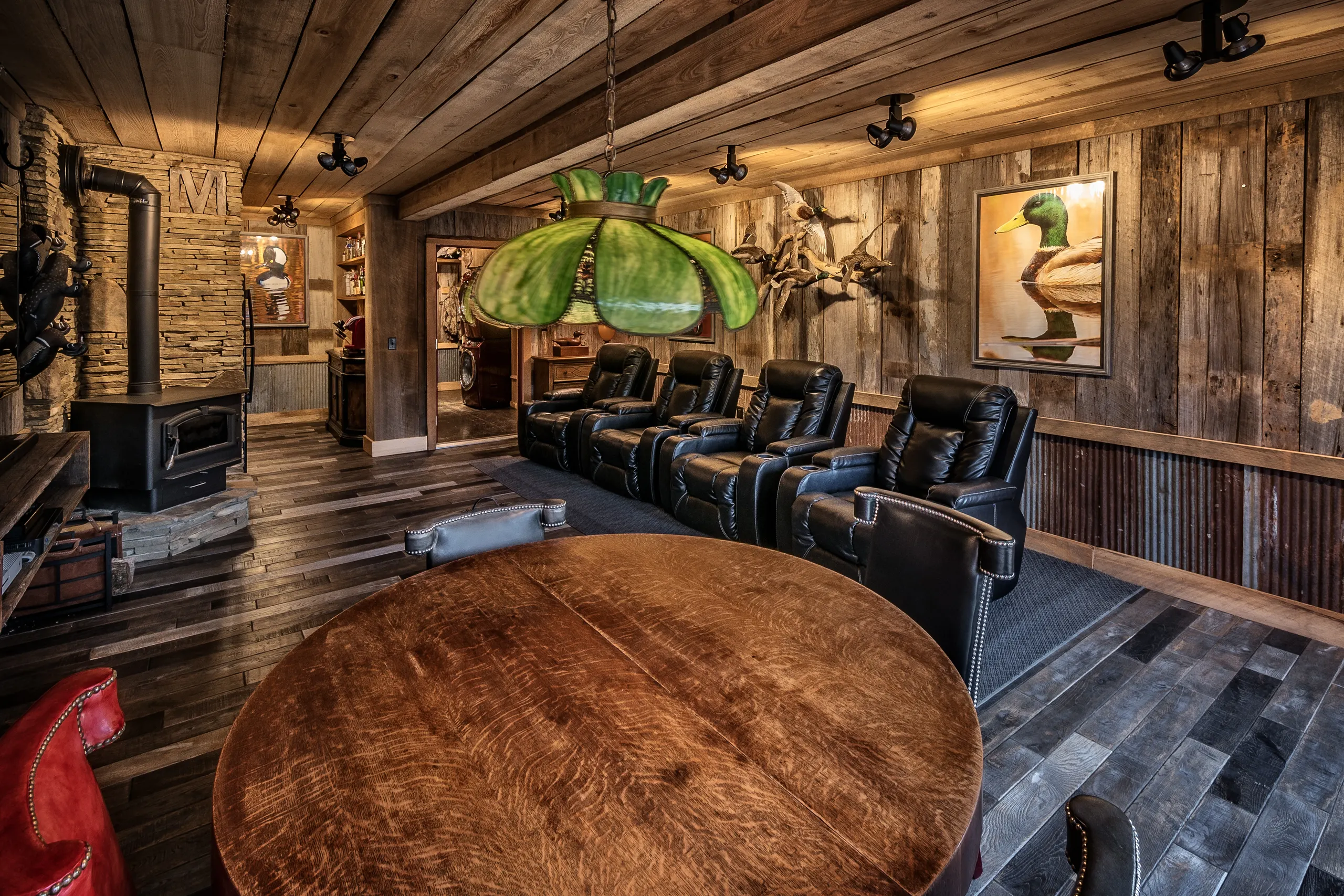The lounge inside, with reclaimed wood walls, leather recliners and a round table
