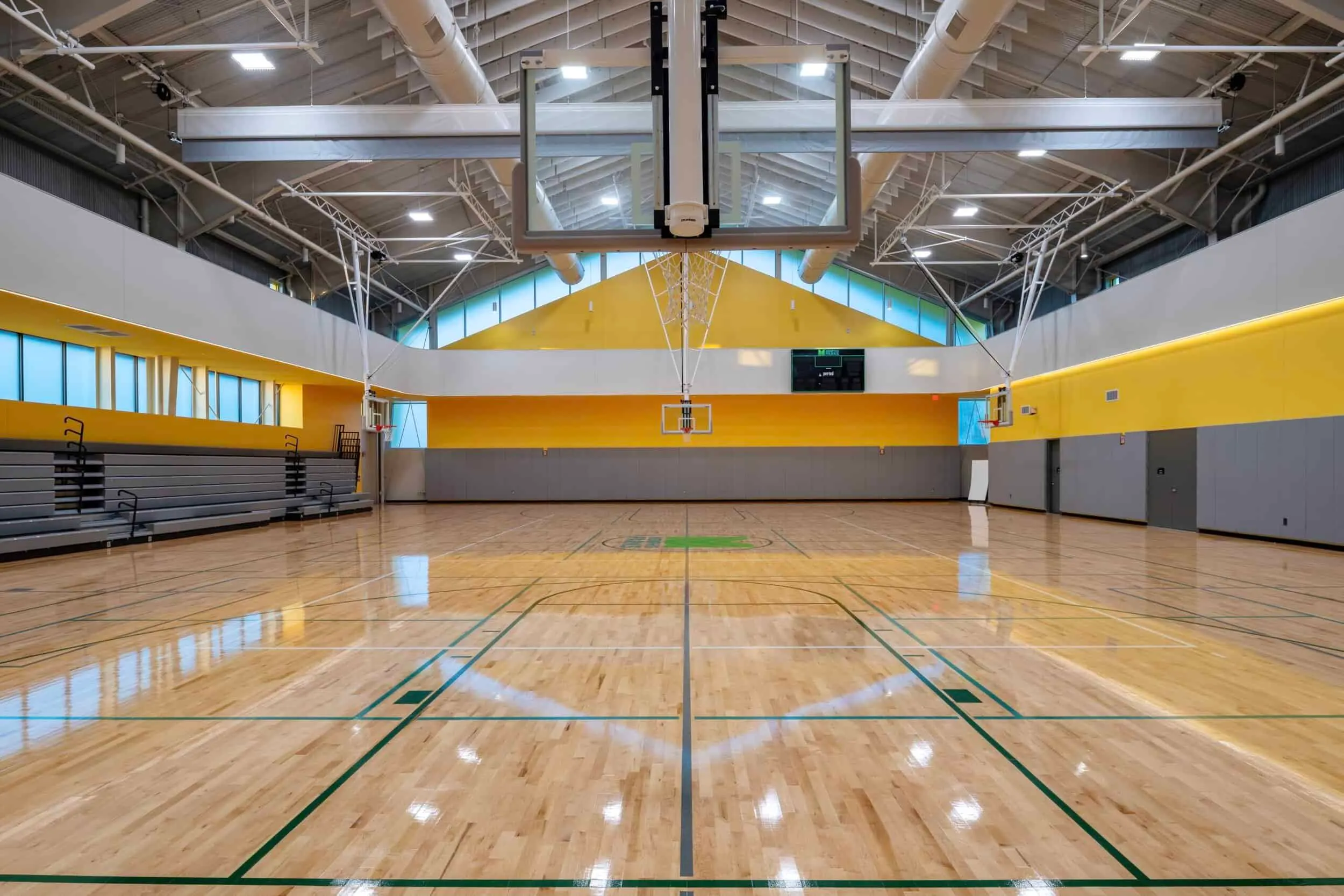 The gymnasium, with yellow walls and a clerestory under the roof trusses