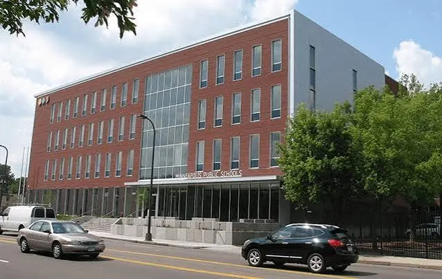 A four-story brick school building on a city street