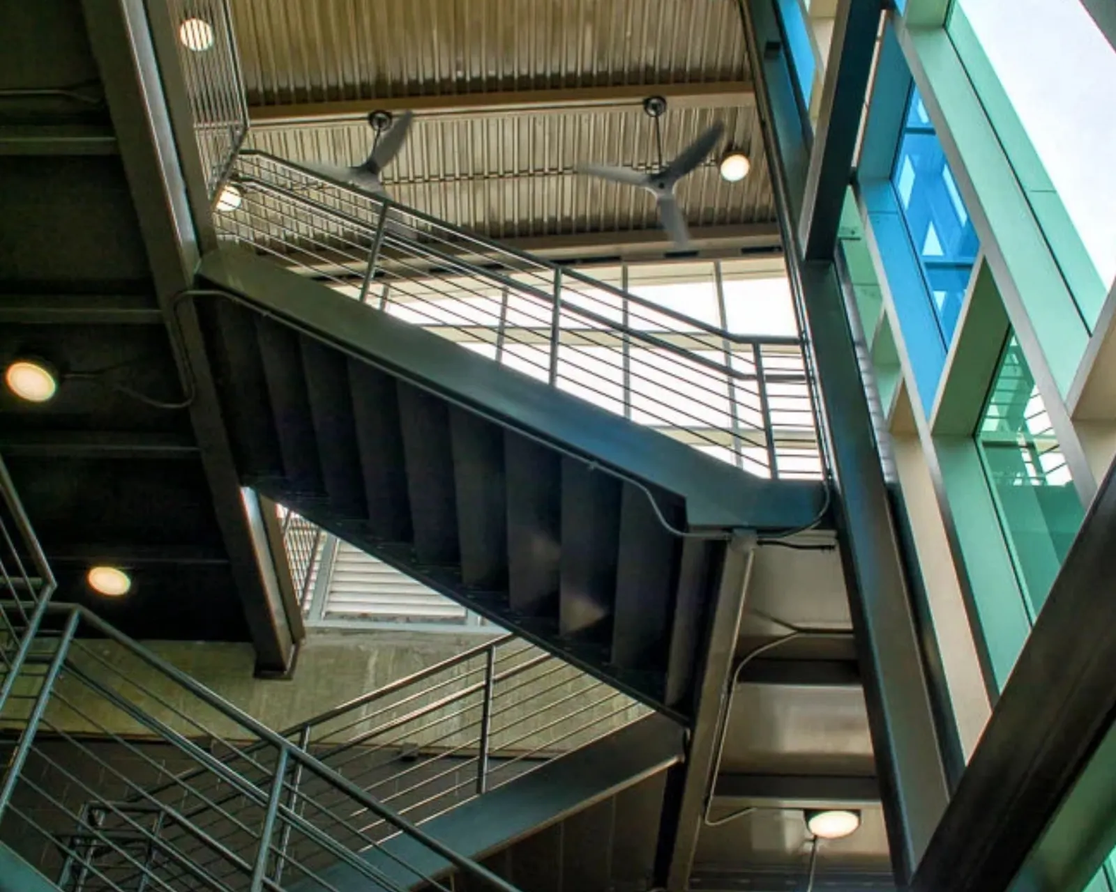 Inside the stair tower, steel stairs against colored glass
