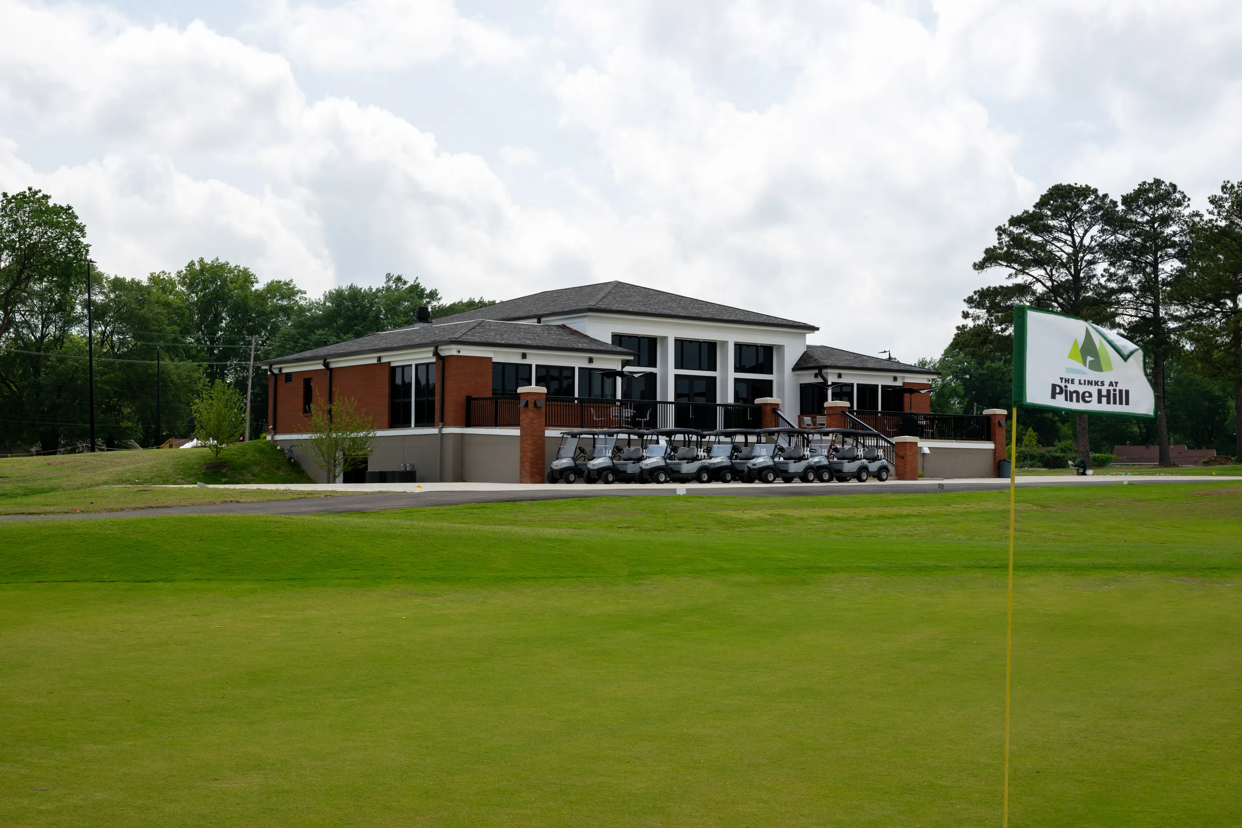 The clubhouse from the course, a Pine Hill flag in the foreground