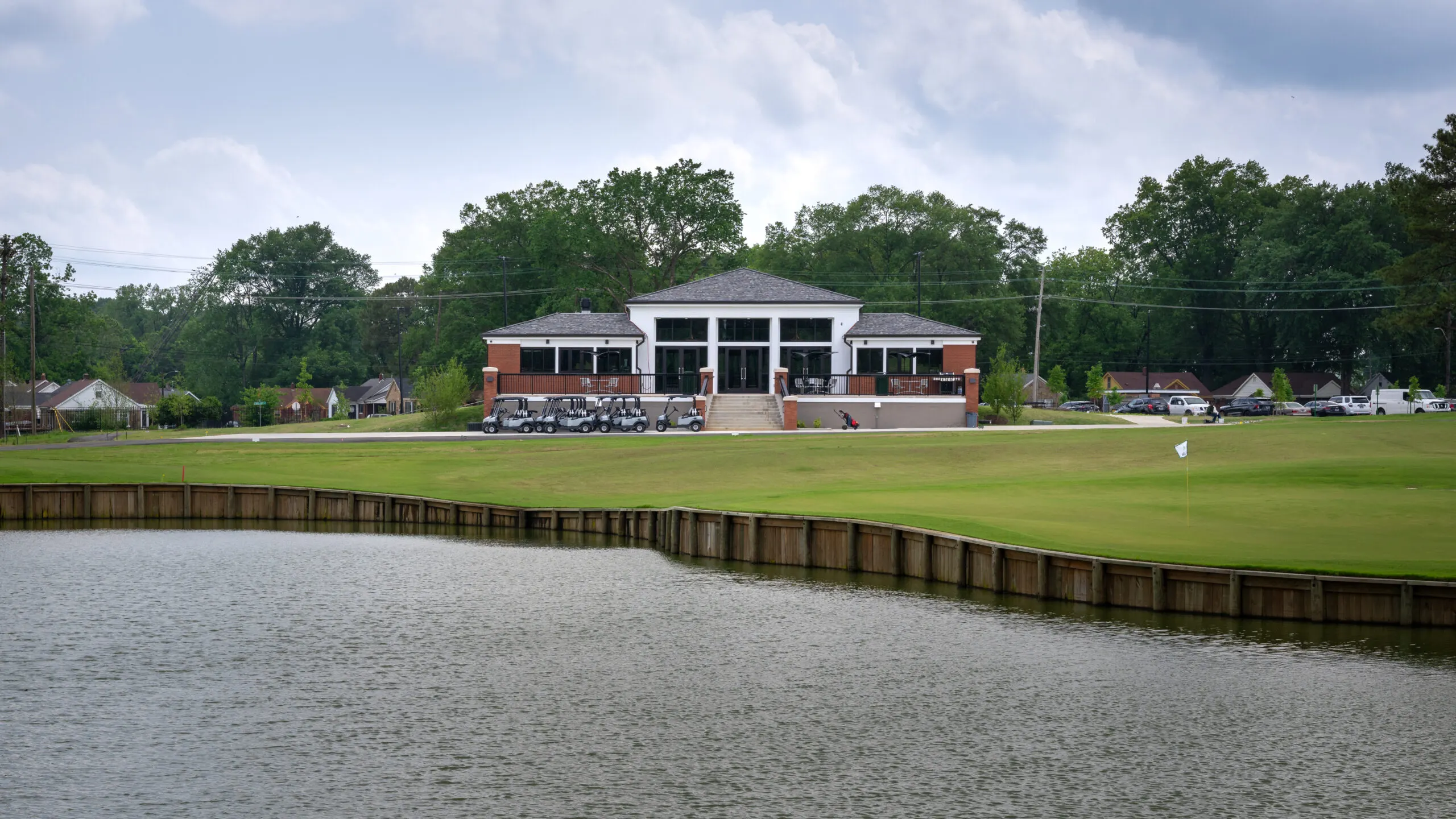 The clubhouse across a pond, carts lined up out front