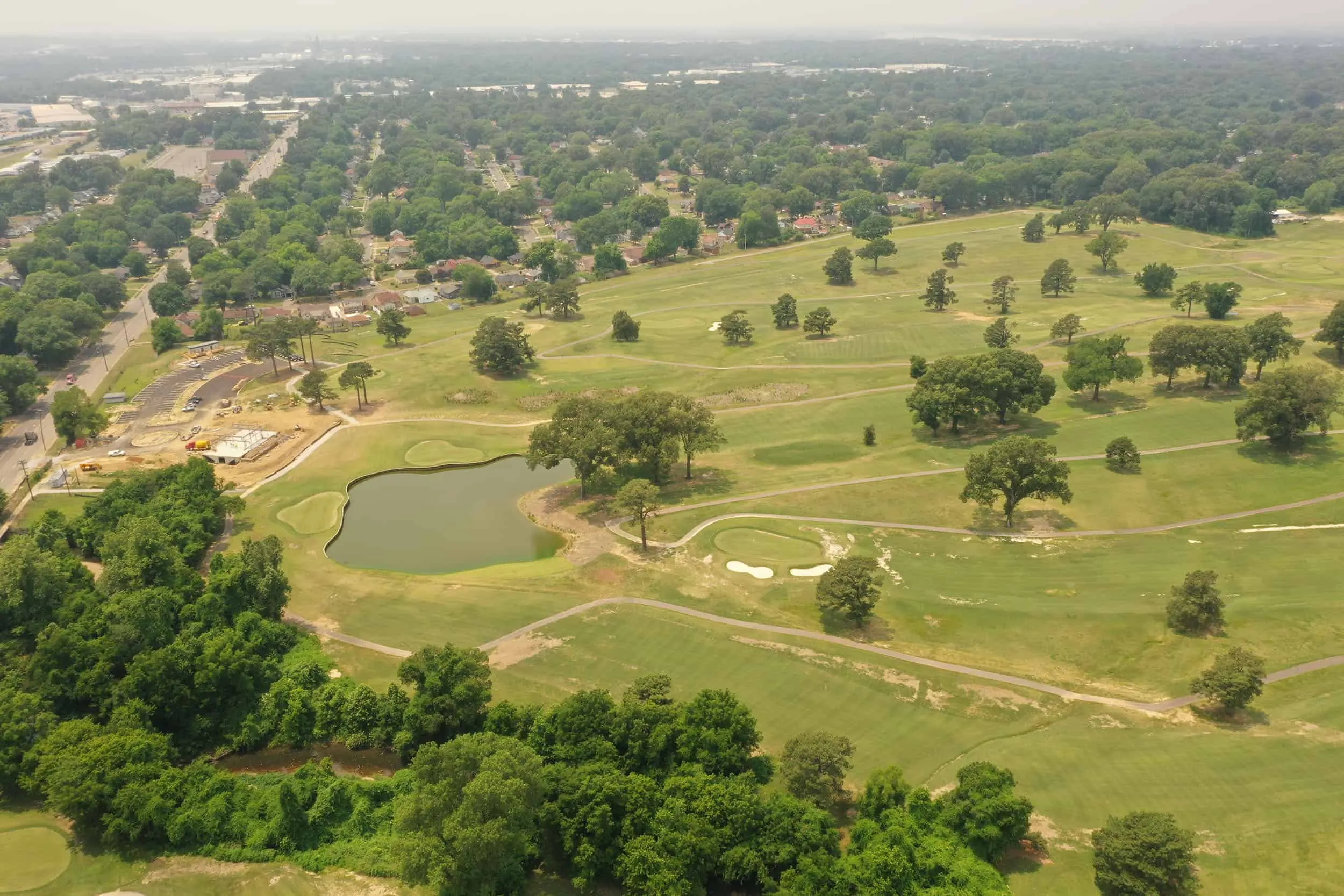 Aerial view across the course and its pond toward the city