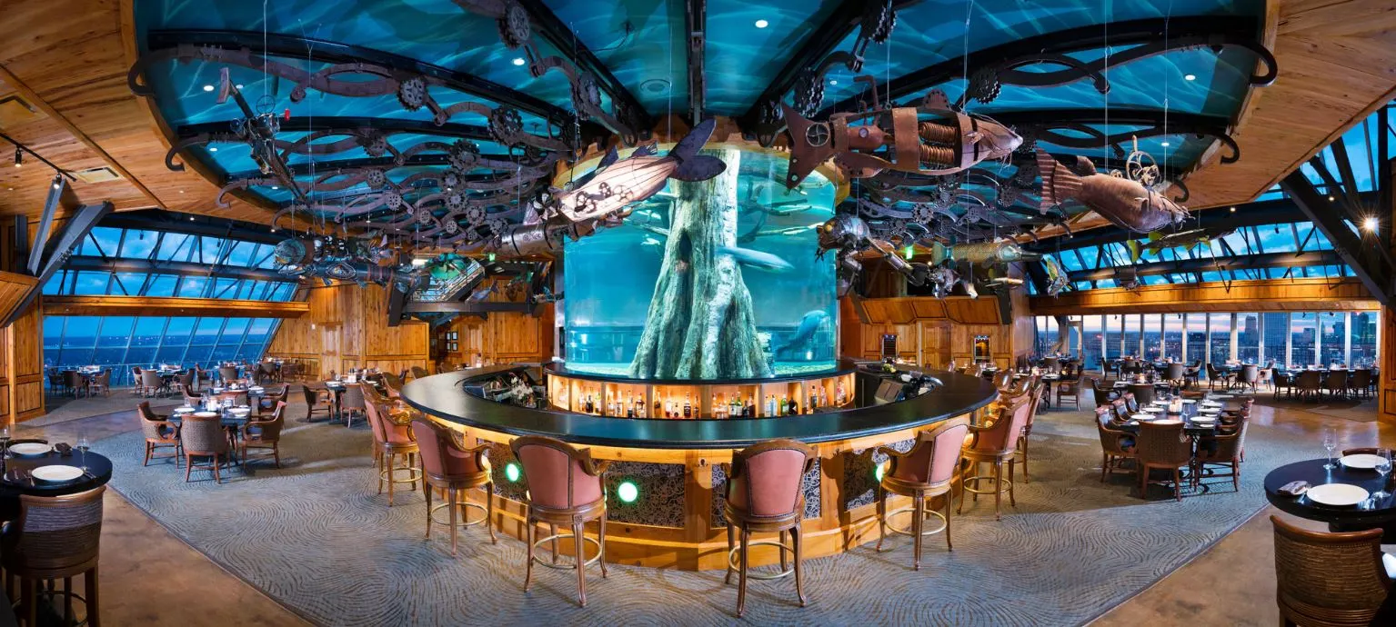 The circular bar at the Pyramid's apex, built around a cypress-stump aquarium under a painted ceiling