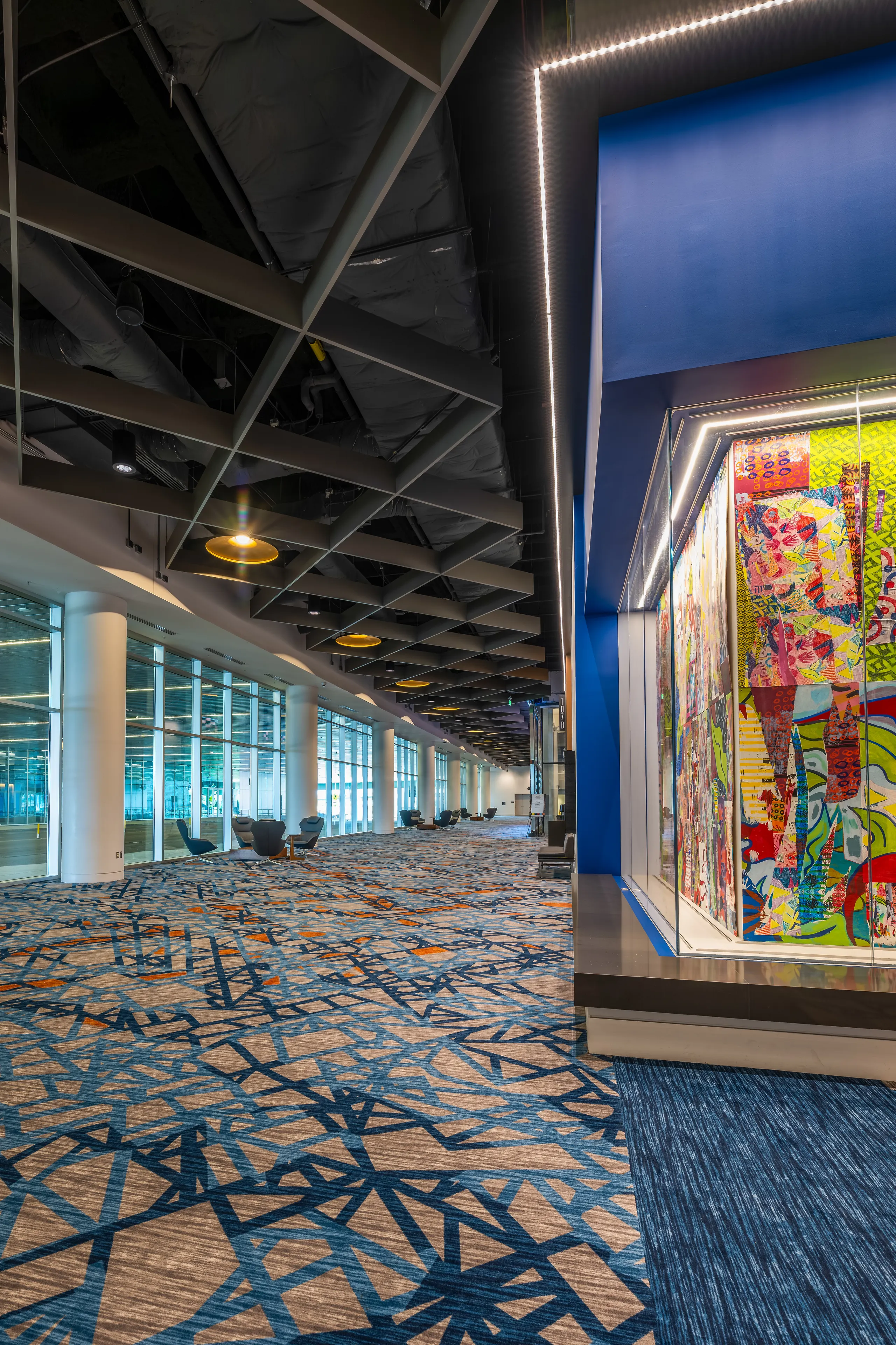 A narrow view down the concourse past a colorful art wall