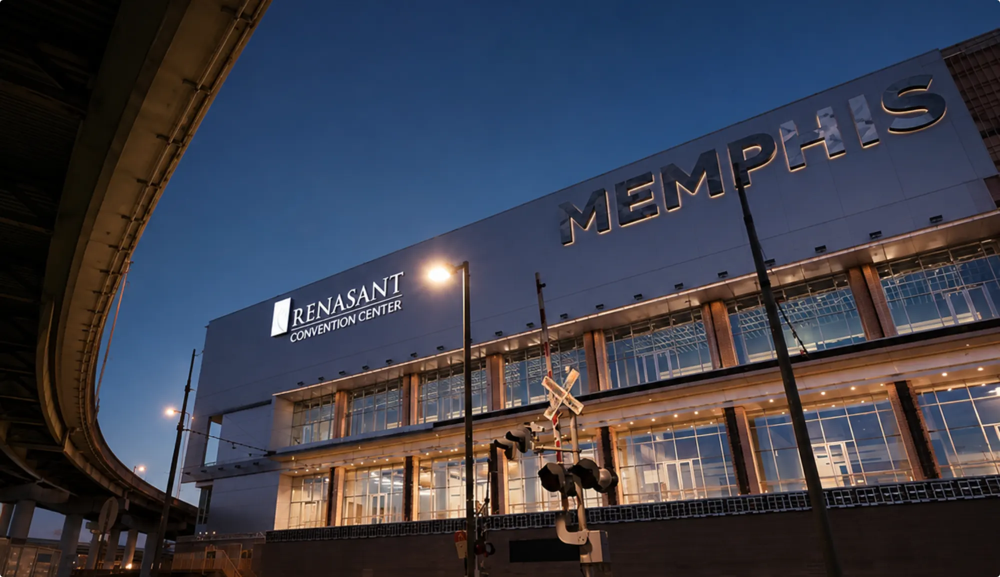 The Memphis facade lit at dusk beside the curving overpass