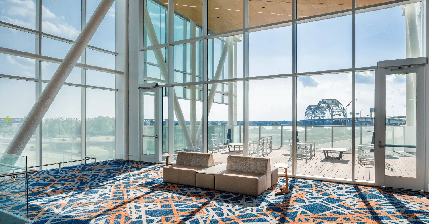 A glass-walled lounge looking out to the river and bridge