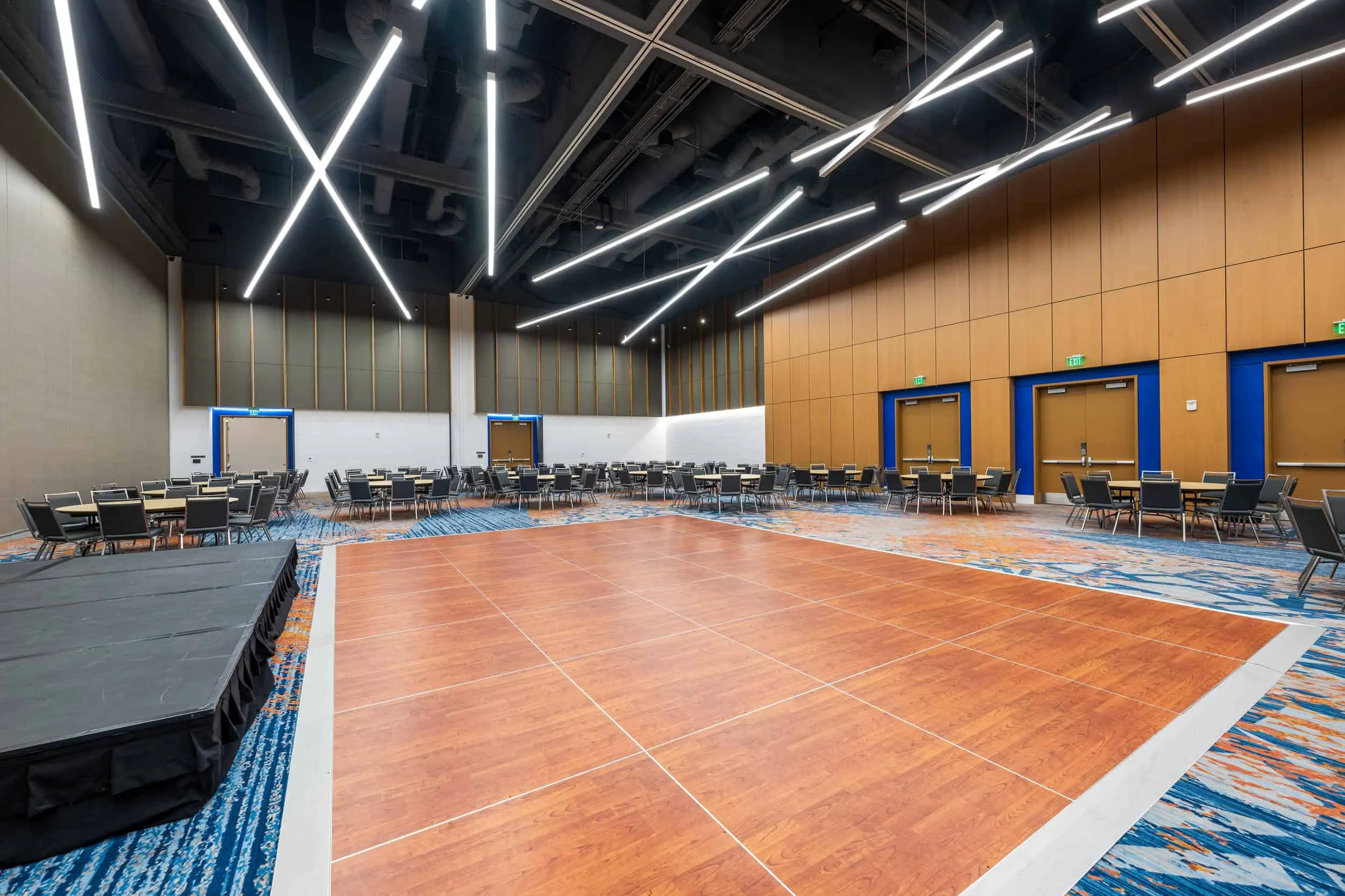 An exhibit hall with a dance floor and stage