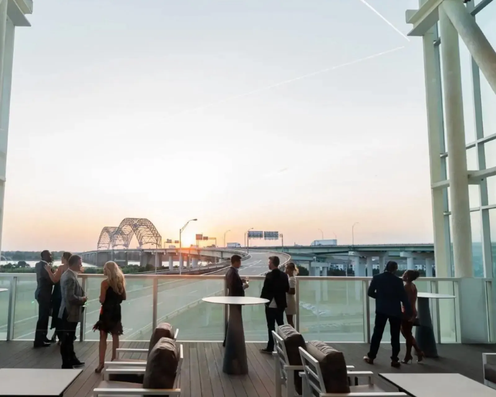 Guests on the terrace at sunset, the bridge beyond