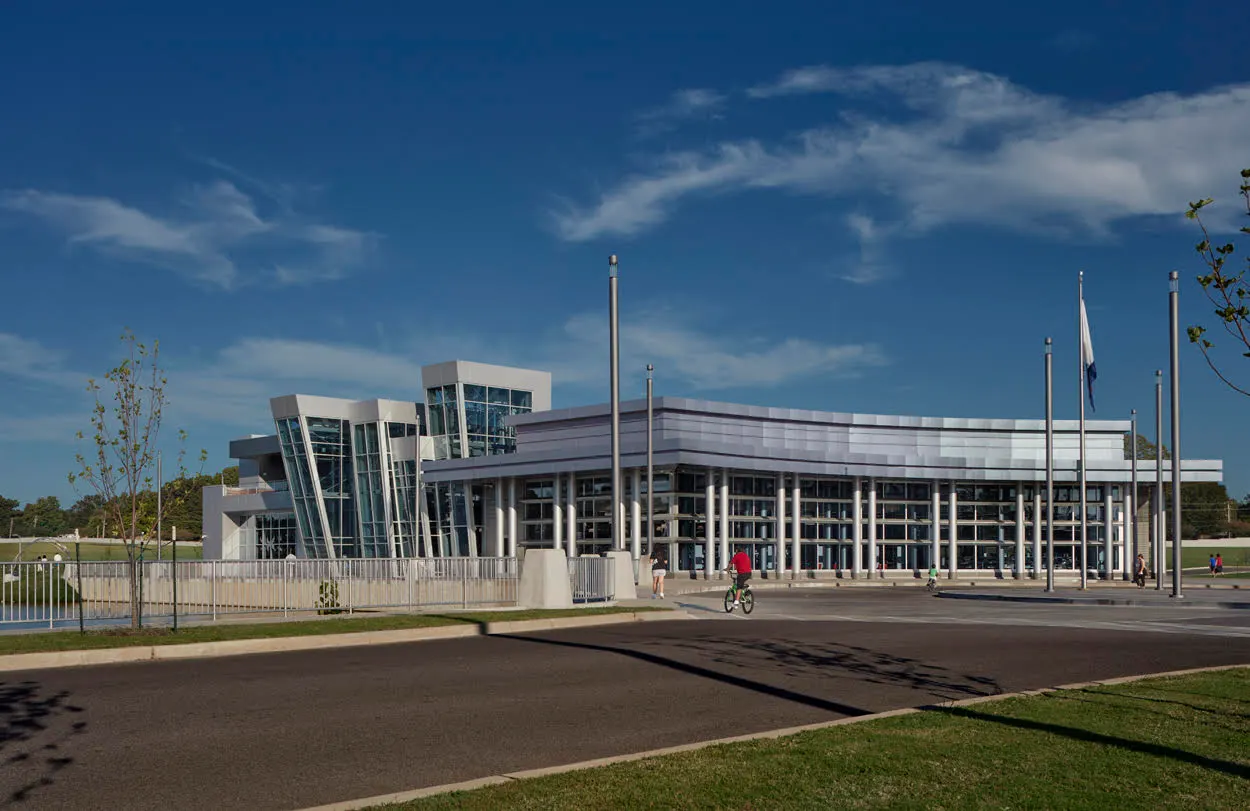 The civic center's glass front and entry drive under a blue sky