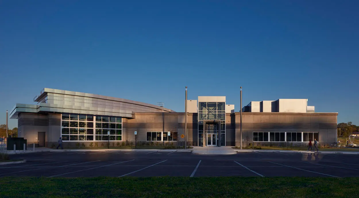 The library's entrance front across the parking court at dusk