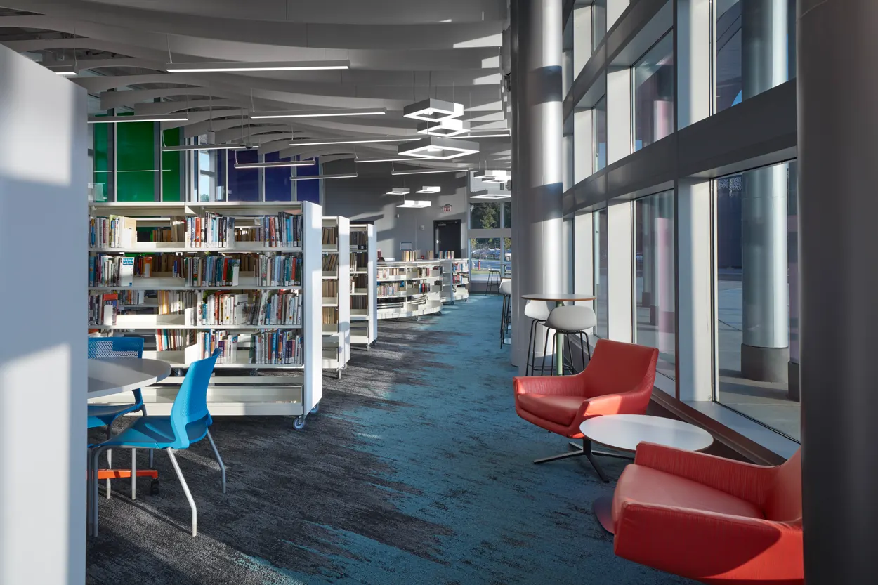 Reading chairs along the glass wall beside the stacks