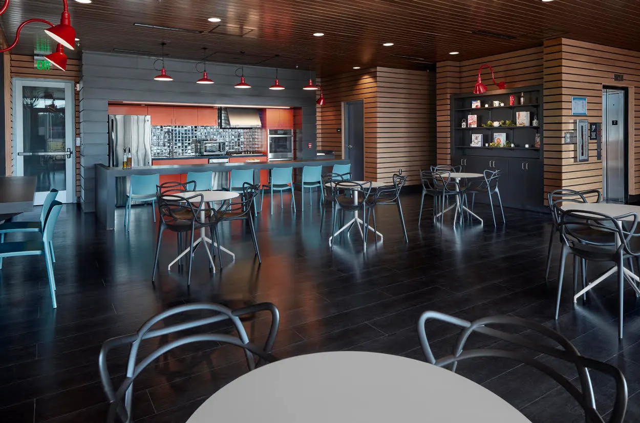 The café, with bar seating and wire chairs on a dark wood floor