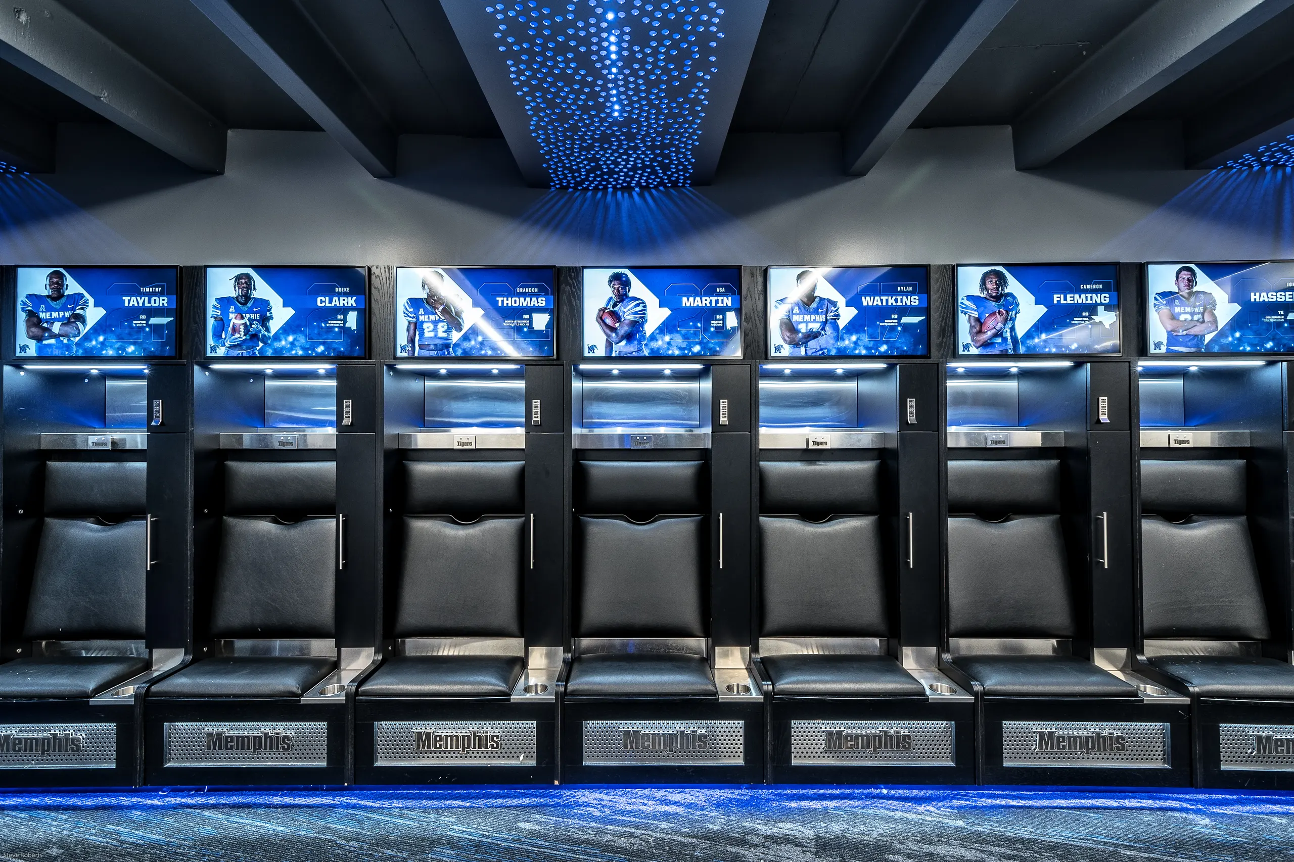 A row of lit lockers with player screens overhead