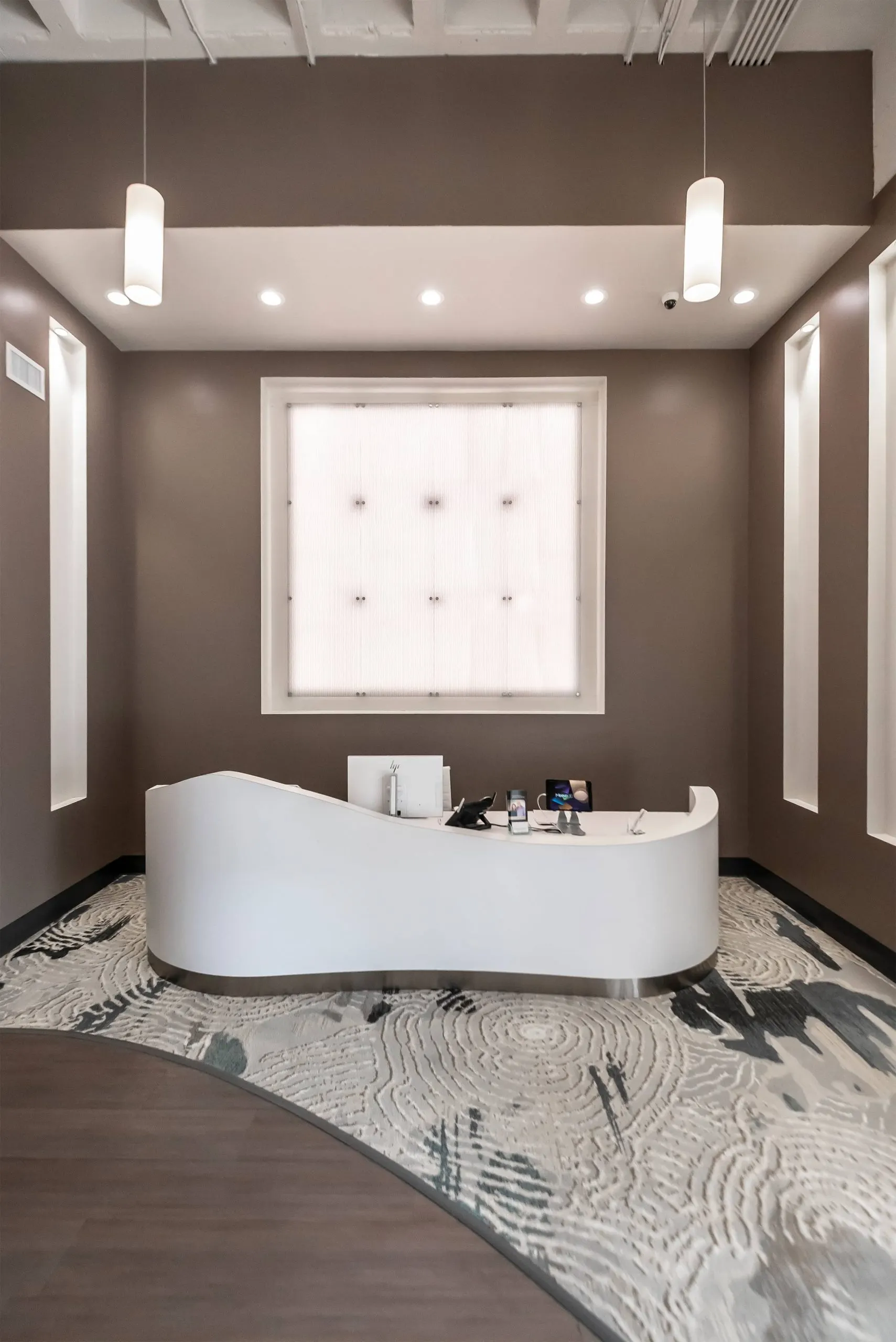 The reception desk, a sculpted white form on a patterned floor